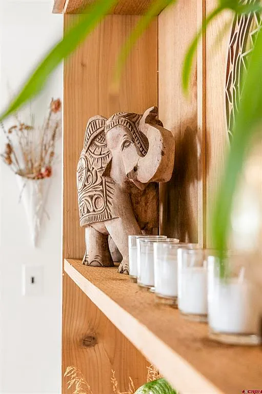 Carved wooden elephant on a wooden shelf with candles